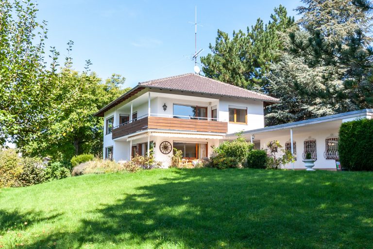 Zweistöckiges Wohnhaus mit Garten und Bäumen in Starnberg.