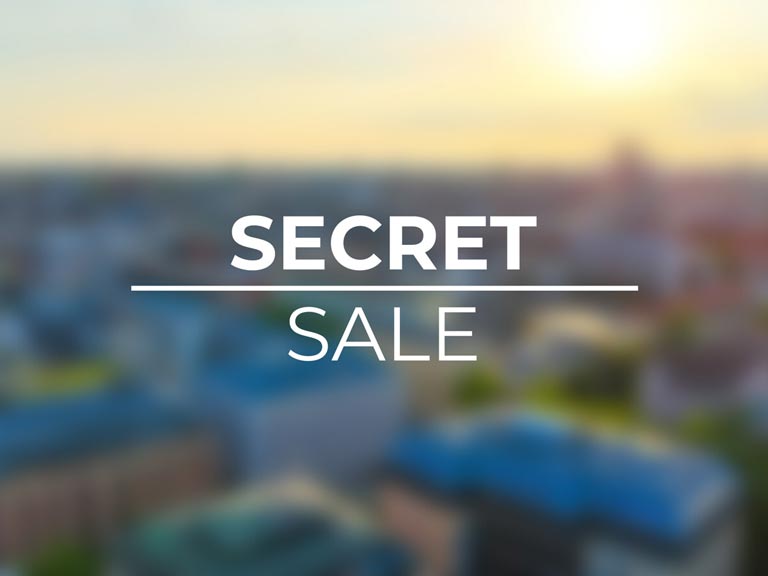 Weiße Aufschrift „SECRET SALE“ über einer unscharfen Stadtansicht mit blau gedeckten Gebäuden und warmem Abendlicht